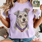 Mujer usando playera lavanda con retrato ilustrado personalizado de un perro gris y beige con arnés morado.
